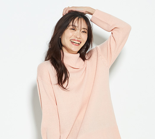 タートルネックニットプルオーバーを着用した女性の写真