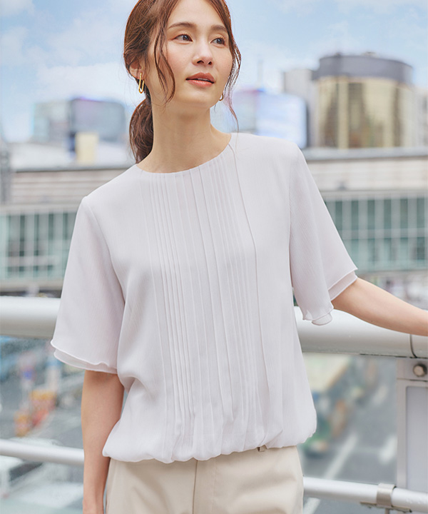 プリーツ Tブラウス、バーズアイストレッチクロップドパンツを着用した女性の画像（アンカーリンク）