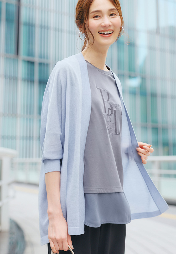 ドルマンスリーブシアーカーディガン、シアー切り替えレイヤード風刺しゅうTシャツ、ワイドパンツを着用した女性のアップの画像