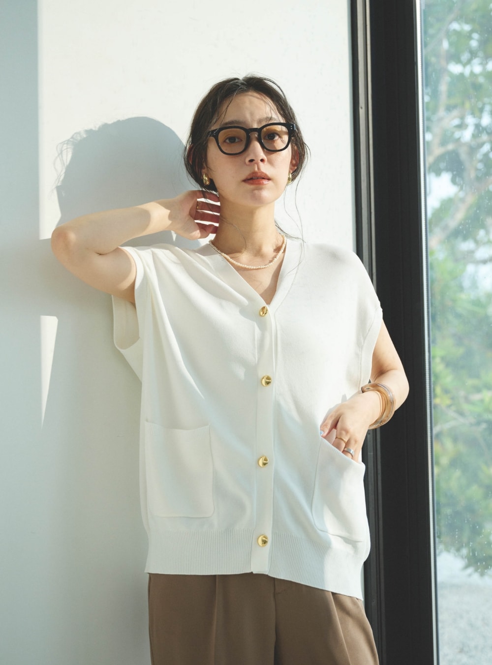 《洗える》サマ美え Vネック金釦ニットベストと《防シワ》サマナチュラリュクス センタープレステーパードパンツを着用した女性１