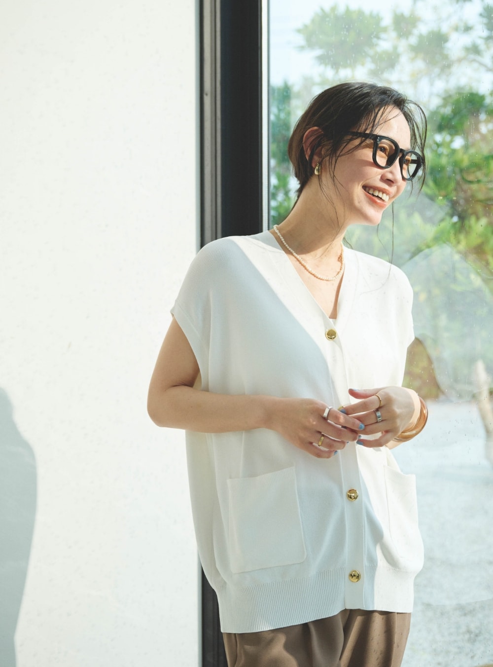 《洗える》サマ美え Vネック金釦ニットベストと《防シワ》サマナチュラリュクス センタープレステーパードパンツを着用した女性２