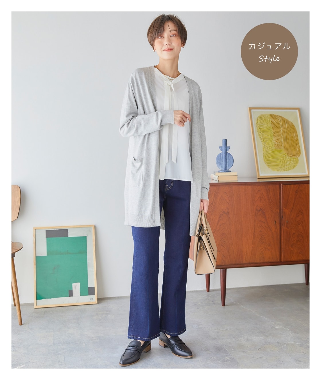 ロングトッパーカーディガンを着用した女性が片手にバッグを持っている写真（カジュアルStyle）