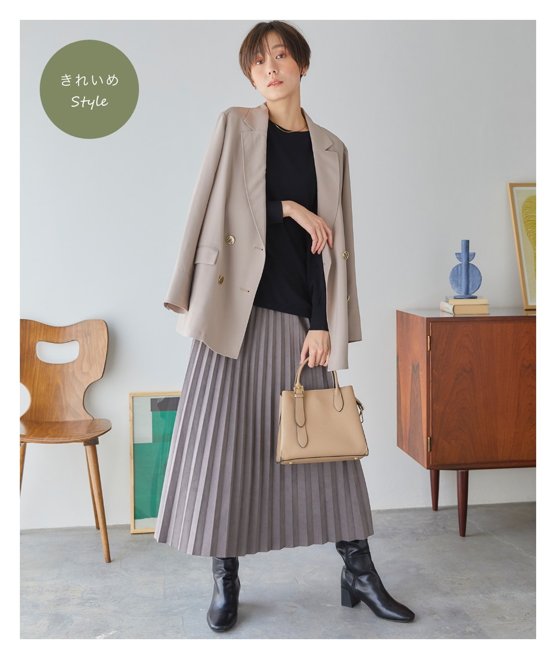 ドルマンニットプルオーバーを着用した女性が片手にバッグを持っている写真（きれいめStyle）