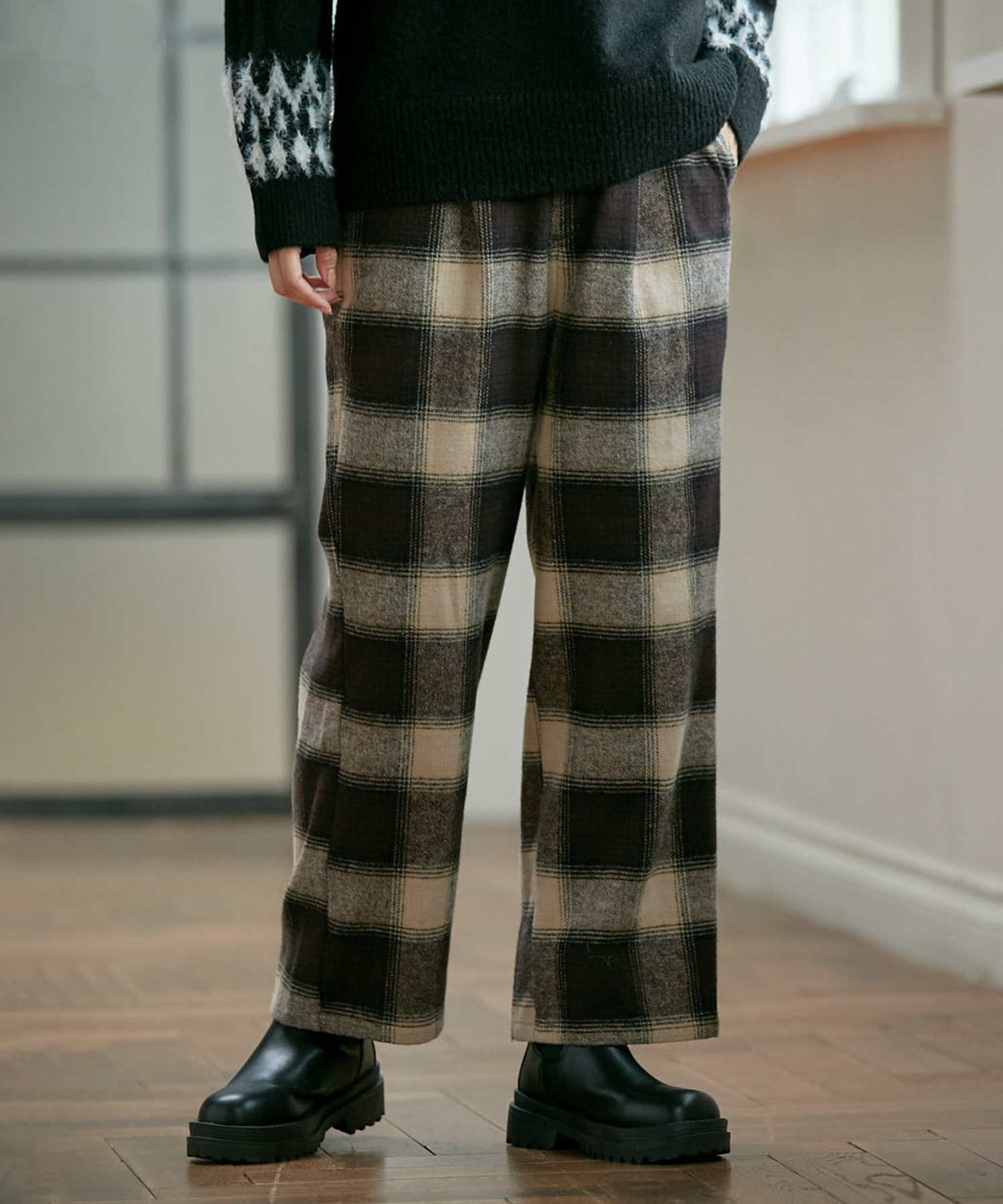 チェックタックストレートパンツを着る女性