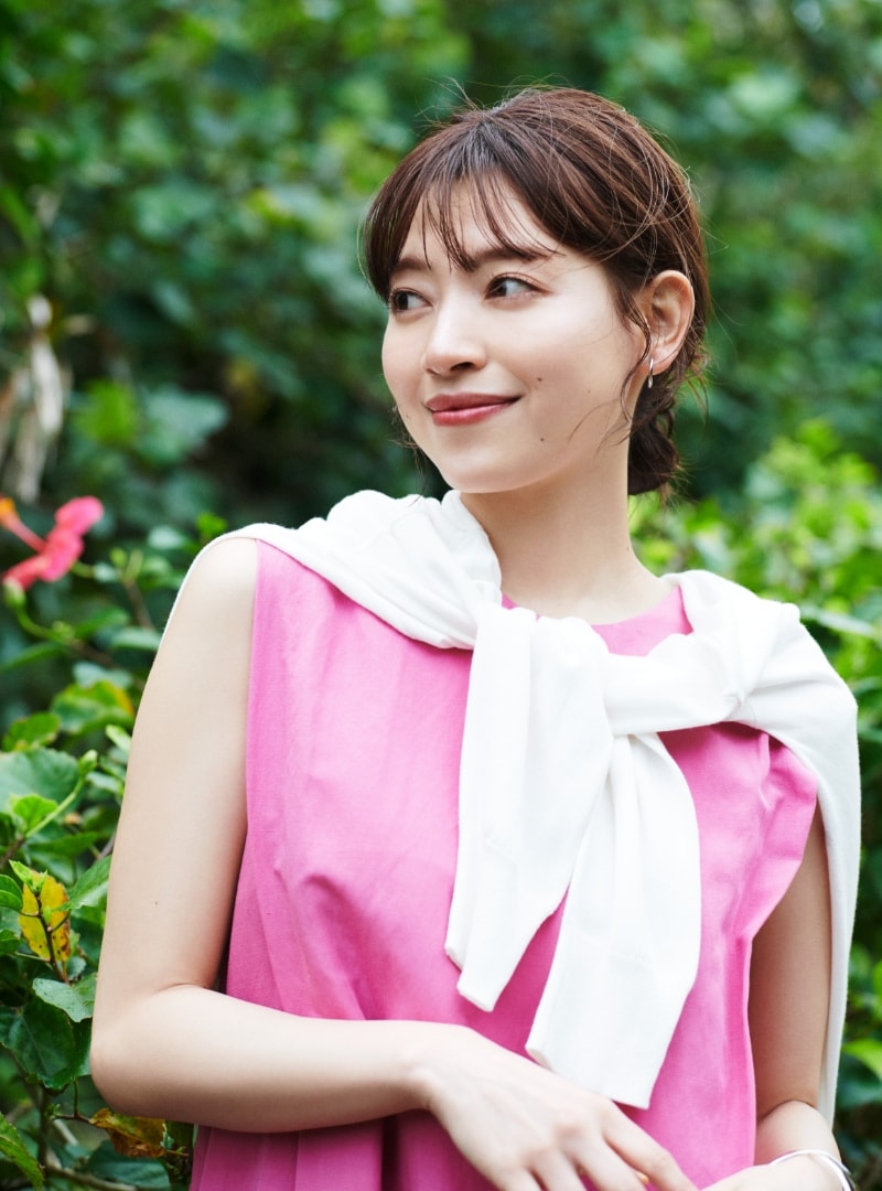 LINEN RAYONワンピースとUV PREMILKニットカーディガンを着用した女性が右側を見ている写真