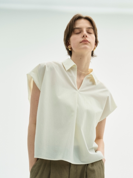 ホワイト色のナイロンタスランスキッパーシャツ【AIRY MOTION】を着用した女性