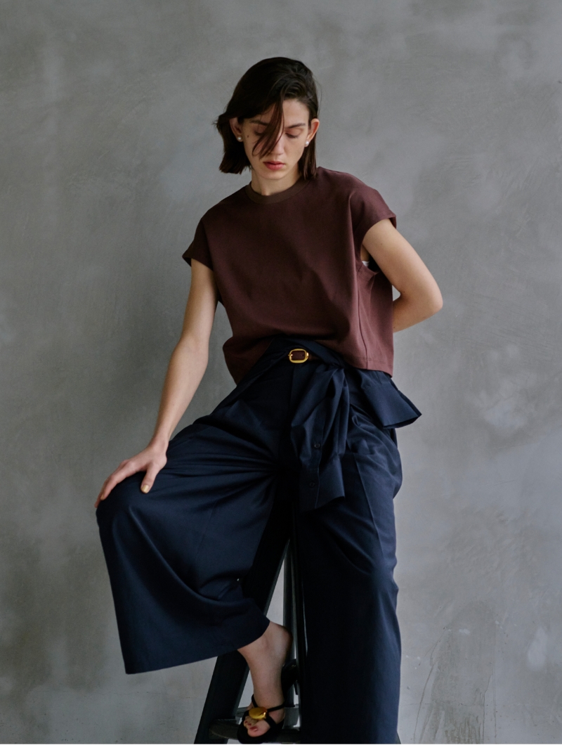 ブラウン色のTops・ネイビー色のShirtとPantsを着用した女性の画像